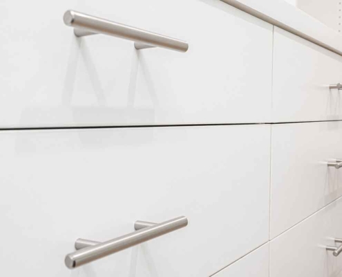 Brushed nickel handles make a statement with clean lines and a flattering white backdrop provided by the drawers.